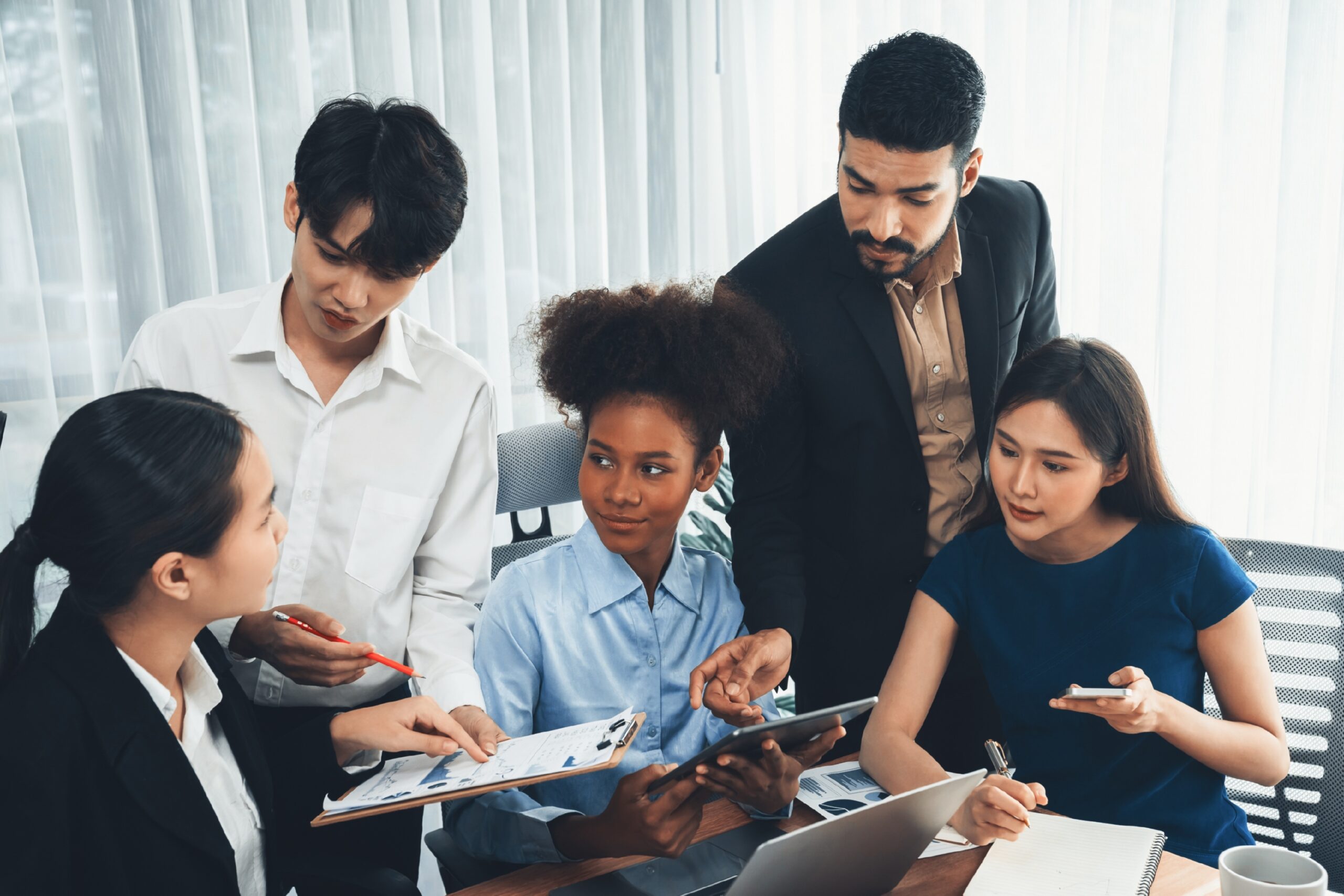 Happy diverse business people work together, discussing in corporate office. Professional and diversity teamwork discuss business plan on desk with laptop. Modern multicultural office worker. Concord
