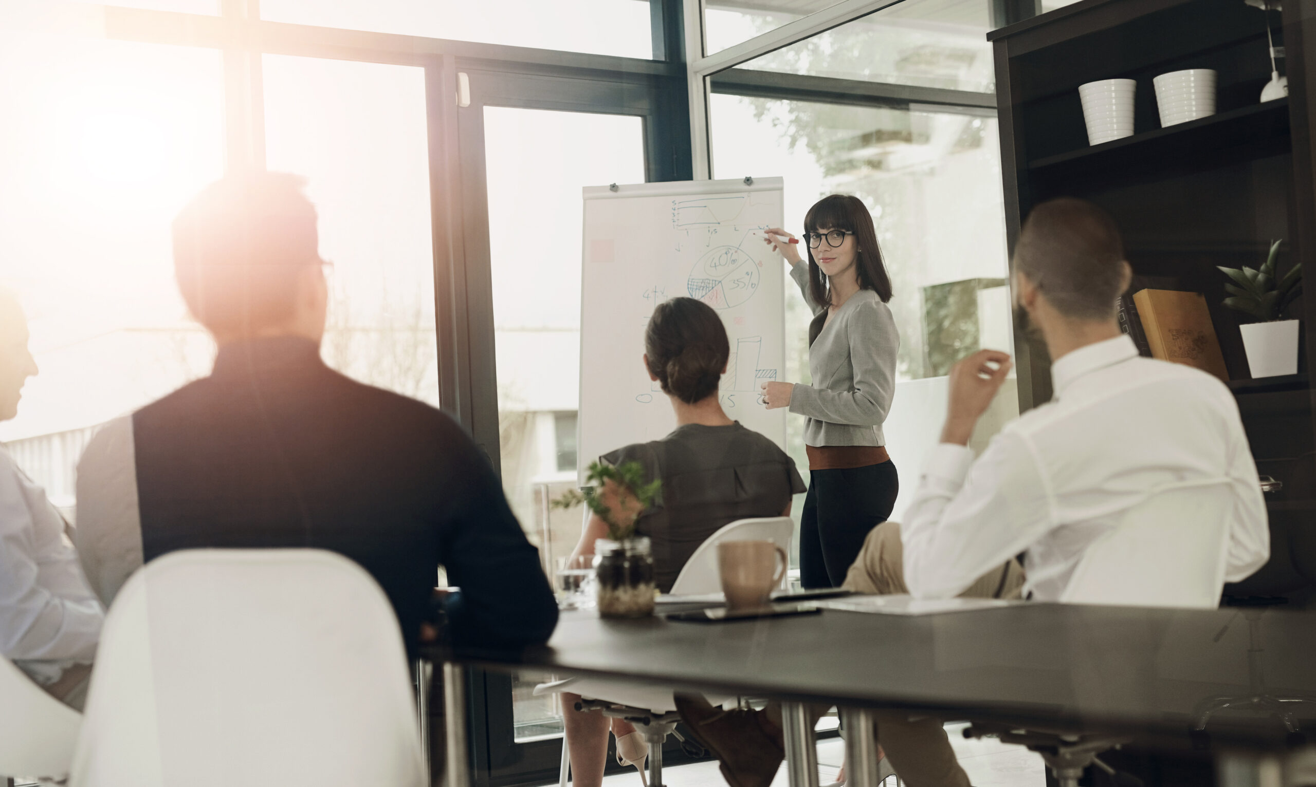 Business presentation, woman or speaker by board for teaching, advice tips or skill development in meeting. Education, workshop or leaders talking in mentorship, training or coaching for learning.
