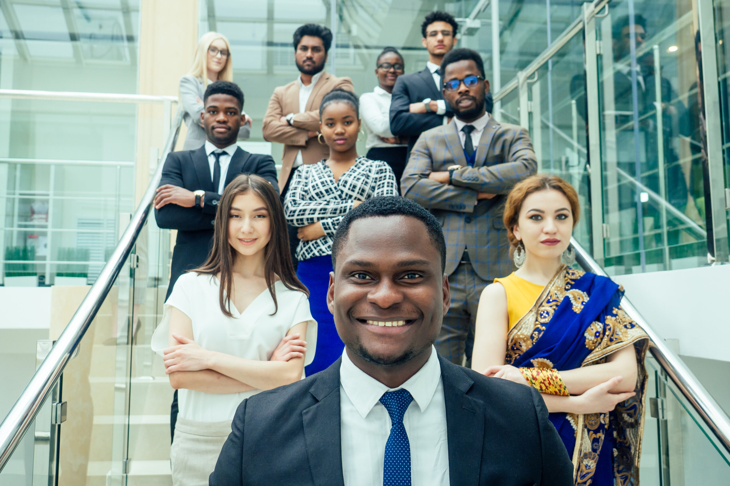 Multi Nationality of business people : indian, korean, afro-american and caucasian stand on the stairs in a modern office with panoramic windows.career enhancement concept